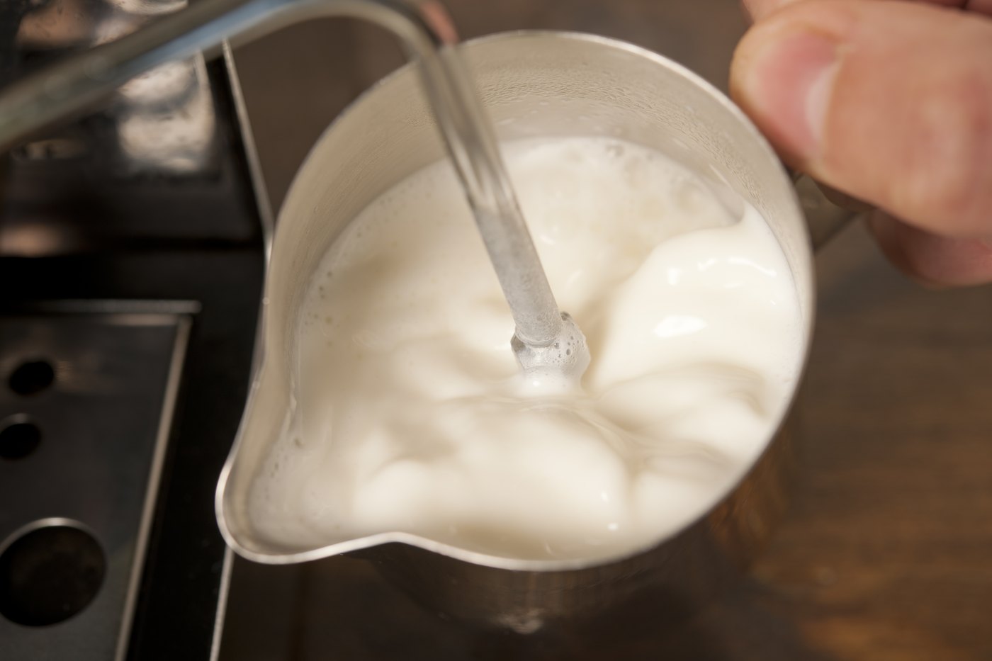 牛乳に蒸気で空気を入れ、泡立て始める工程